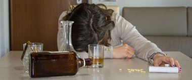 Uyuşturucu, uyuşturucu ve alkol kullandıktan sonra kafası masada dinlenen bir kadının görüntüsü. Yatay Pankart