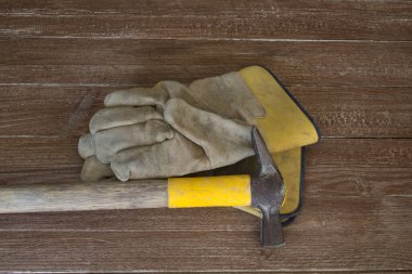 Bir çift iş eldiveni ve çekiç resmi. Ağır iş ve olası yaralarının bir göstergesi.