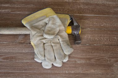 Bir çift iş eldiveni ve çekiç resmi. İş yerinde meydana gelen kazaların temsili