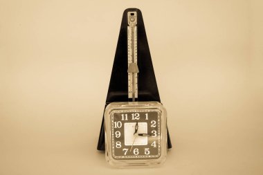 Bir masa saati ve metronomun resmi. Geçen tampona ve ölçümüne referans ver