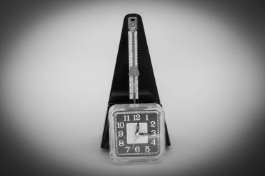 Bir masa saati ve metronomun resmi. Geçen tampona ve ölçümüne referans ver