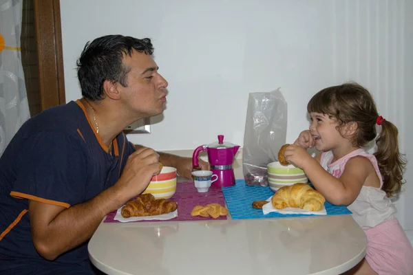 Imagen Padre Joven Soplando Beso Hija Sonriente Mientras Desayunan Por —  Fotos de Stock