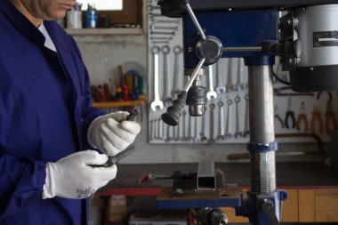 Image of a blacksmith showing a broken drill bit. Reference to poor quality material