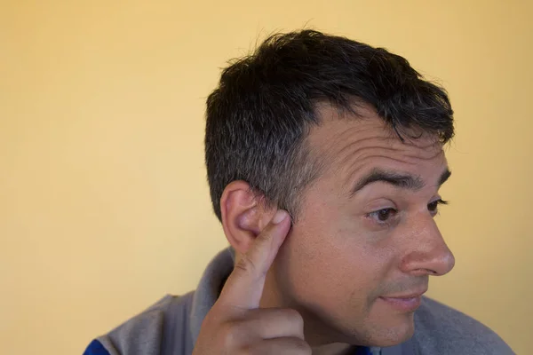 Image of a man indicating the appearance of the first white hair on the temples. Reference you have possible remedies to counteract the fall and the appearance of white hair
