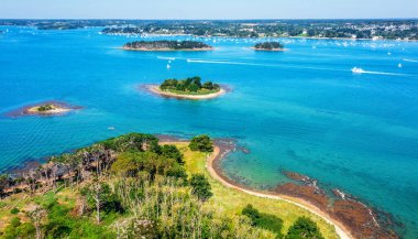 Small islands scattered in the blue water of the Gulf of Morbihan on atlantic coas of Brittany, France
