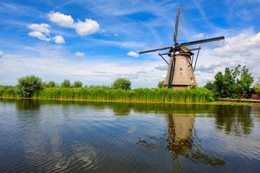 Hollanda, Güney Hollanda 'daki Kinderdijk yel değirmeni parkında tarihi bir ahşap değirmeni kanal suyuna yansıyor.