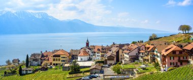 Lavaux üzüm bağı teraslarındaki Chexbres köyü, Lozan, İsviçre, Cenevre Gölü ve Alpler 'in panoramik manzarası. Lavaux, manzaralı şarap rotasıyla ünlüdür ve UNESCO 'nun bir dünya mirası alanıdır.