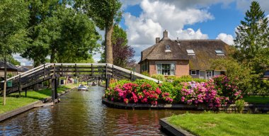 Hollanda 'nın cennet Giethoorn köyündeki su kanalı ve geleneksel Hollanda tuğla evleri manzaralı.