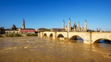 Zaragoza şehrinin panorama 'sı, Ebro nehrinin üzerindeki ortaçağ taş köprüsü Puente de Piedra manzarası ve İspanya' nın Sütun Leydisi Katedrali.