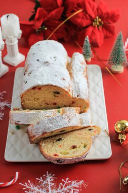 Yılbaşı Stollen 'ı taşra arka planında. Geleneksel Noel Şenlikli Pasta Tatlısı. Almanca. Noel için çalınmış, Kırmızı Konsept