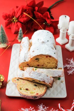 Yılbaşı Stollen 'ı taşra arka planında. Geleneksel Noel Şenlikli Pasta Tatlısı. Almanca. Noel için çalınmış, Kırmızı Konsept