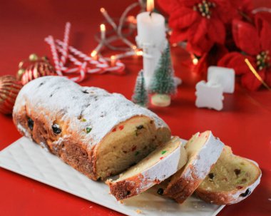 Köy geçmişinde dilimlenmiş Noel Stollen. Geleneksel Noel Şenlikli Pasta Tatlısı. Almanca. Noel için çalınmış, Kırmızı Konsept
