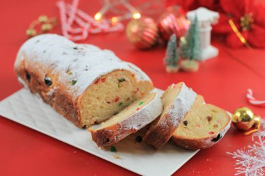 Yılbaşı Stollen 'ı taşra arka planında. Geleneksel Noel Şenlikli Pasta Tatlısı. Almanca. Noel için çalınmış, Kırmızı Konsept