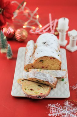Yılbaşı Stollen 'ı taşra arka planında. Geleneksel Noel Şenlikli Pasta Tatlısı. Almanca. Noel için çalınmış, Kırmızı Konsept