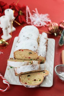 Yılbaşı Stollen 'ı taşra arka planında. Geleneksel Noel Şenlikli Pasta Tatlısı. Almanca. Noel için çalınmış, Kırmızı Konsept