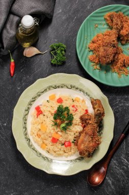 Kızarmış tavuklu tereyağlı pilav, Nasi Goreng Mentega ve Ayam Goreng Serundeng. Seramik Plaka, Siyah Arkaplan ServisiName