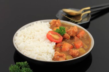 Japon körili tavuk ve patlamış mısır, yanında beyaz pirinç. Kara Arkaplanda İzole Edilmiş