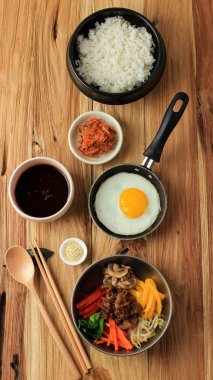 Tahta Masa, Pirinç, Saute Mix Sebze, Mantar, Sığır Bulgogi, Bibimbap Baharat Sosu, Kimchi ve Sunny Side Egg üzerine Üst Manzara Bibimbap Malzemeleri.