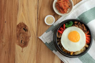 Geleneksel Kore yemeği: Bibimbap pilavı, karışık soslu sebze, sığır eti ve yumurta. Kırmızı Baharatlı Bibimbap Sosu ve Susam Yağı ile servis edilir. Metin için Boşluğu Kopyala
