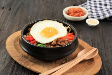 Geleneksel Kore yemeği: Bibimbap pilavı, karışık soslu sebze, sığır eti ve yumurta. Kırmızı Baharatlı Bibimbap Sosu ve Susam Yağı ile servis edilir.