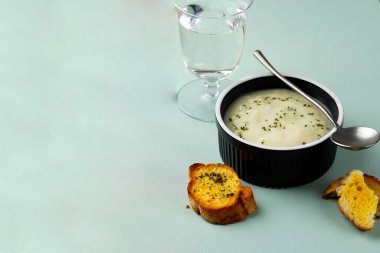 Creamy Soup with Garlic Bread. Served on Black Bowl 