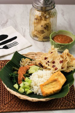 Nasi Pecel, Indonesian Traditional Menu with Spicy Peanut SAuce, Tempeh, Boiled Vegetable, and Fried Tofu, Rempeyek, Popular for Breakfast, Dinner, or Lunch from East Java