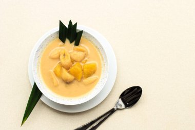 Top View Kolak Pisang Ubi or Banana and Sweet Potato Compote is Popular Indonesian Dessert made from Banana Sweet Potato Cooked with Coconut Milk, Palm Sugar, and Pandan Leaves. Popular during Ramadan