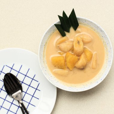 Top View Kolak Pisang Ubi or Banana and Sweet Potato Compote is Popular Indonesian Dessert made from Banana Sweet Potato Cooked with Coconut Milk, Palm Sugar, and Pandan Leaves. Popular during Ramadan