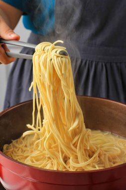 Asian Female Hand Boiled Asian Noodle (Mie Telur or bakmi), Cooking Process in the Kitchen 