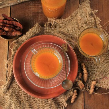 Top View Jamu Kunyit Asam, Traditional Indonesian Herbal Tonic Drink. Made from Turmeric, Tamarind, and Palm Sugar. Usually Served To Boost Imune