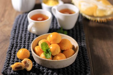 Selected Focus Nastar Durian, Cookies with Durian Jam Filling, Served in Brown Bowl with Mint Leaf as Garnish.