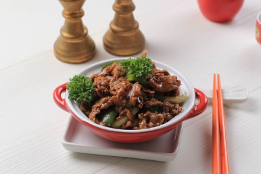 Sapi Lada hitam, Indonesian and Chinese cuisine, stir fried beef with black pepper sauce and red bell peppers, Served on Red Plate