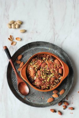 Om Ali ya da Umm Ali, Islak Pasta Ekmek, Süt ve Kuru Üzüm Yığını. Üstünde Rose Petal, üstünde COpy Space olan Top View 
