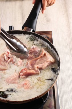 Asyalı kadın aşçı baharatlı ve şifalı tavuk (Ungkep Ayam), mutfakta pişirme işlemi geleneksel Endonezya usulü kızarmış tavuk tarifi yapıyor