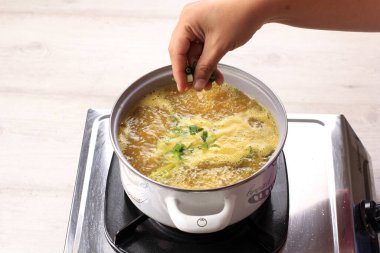 Tavaya doğranmış taze soğanı sarı çorbayla (Soto) ekleyin. Mutfakta Aşçıbaşı ile Aşçılık Süreci
