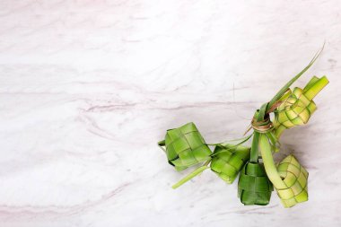 Ketupat (Endonezya) veya pirinç küpü beyaz mermer masa üzerinde. Ketupat, Young Coconut Leaves 'ten yapılmış doğal kaplamalı pirinç köftesi. Bayram Bayramında popülermiş. Üst Görünüm.