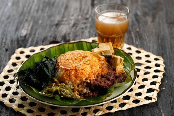 Nasi Padang或 Padang Rice 是印度尼西亚著名的传统食品 米饭配牛肉仁当 木薯叶和绿辣椒粉 木桌上 — 图库照片
