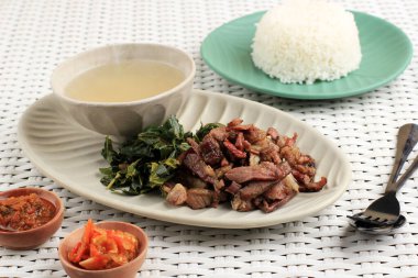 Se 'i Sapi veya Beef Sei Endonezya Geleneksel Tütsülenmiş Et, Kaynamış Cassava Yaprakları ve Sambal Luat veya Sambal Matah ile servis edilir. Endonezya, Nusa Tenggara 'dan tipik yiyecek.