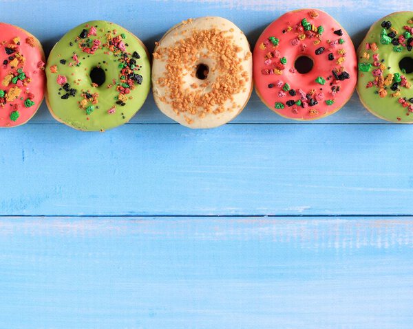 Top View Assorted Doughnut with Colorful Sprinkle Isolated on Blue Wooden Background, Copy Space for Text