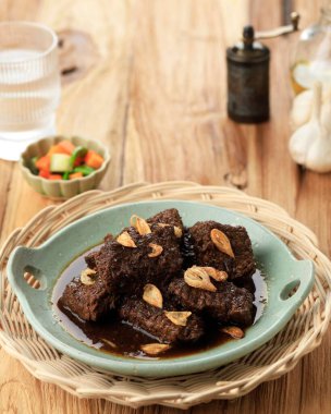 Daging Hitam Palembang or Black Meat Malbi, Jambi and Palembang Authentic Recipe Food. Beef Stew with Sweet Soy Sauce, On Wooden Table clipart