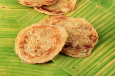 Muz Yaprağı üzerine Roti Parata veya Roti Canai, Kuzu Curry ile servis edilir veya Çikolata Serpiştirme ve Yoğunlaştırılmış Süt ile tepeleme