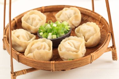 Bambu Tabağı ve Çin Buharlı Ravioli Jiaozi Shuijiao, beyaz arka planda izole edilmiş.