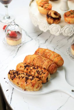 Bolen Lilit 'i ya da Bandung Fırını' ndan Bandung Rolls 'u seçtik. Muzlu hamur işi, çikolatalı ya da ızgara peynirli. Beyaz Mermer masada servis edilir.