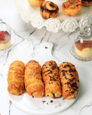 Bolen Lilit 'i ya da Bandung Fırını' ndan Bandung Rolls 'u seçtik. Muzlu hamur işi, çikolatalı ya da ızgara peynirli. Beyaz Mermer masada servis edilir.