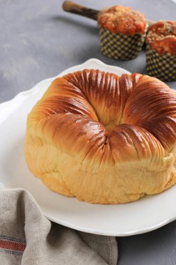 Yün rulo ekmek, ev yapımı Japon Brioche sütlü ve yün gibi güzel bir dokusu var. Beyaz Tabak 'ta ve Arka planda Çörek' te servis edildi. Fırın için Rustik Kavram