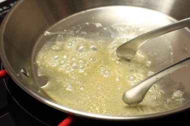 Tereyağı ya da Margarin 'in Parçaları Paslanmaz Fırın Tavasında Eritilmiş Mutfakta Pişirme İşlemi 