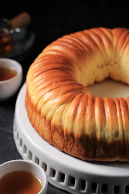 Yün rulo ekmek, ev yapımı Japon Brioche sütlü ve yün gibi güzel bir dokusu var. Beyaz Tabak Koyu Pastane Konsepti Servisi