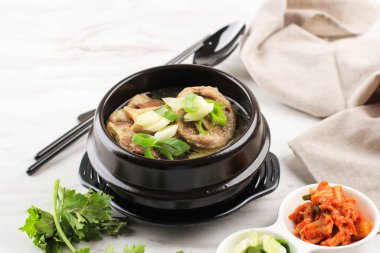 Gori Gomtang (Sokkori Gomtang) veya Kore Oxtail Çorbası, Kimchi ve Dilimlenmiş Yeşil Soğan ile birlikte Kara Kore Bowl 'unda servis edilir.