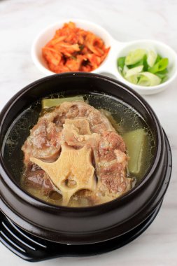 Gori Gomtang (Sokkori Gomtang) veya Kore Oxtail Çorbası, Kimchi ve Dilimlenmiş Yeşil Soğan ile birlikte Kara Kore Bowl 'unda servis edilir.