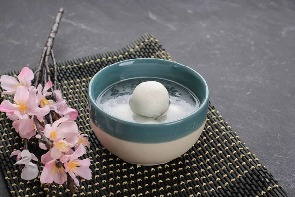 Tang Yuan, Çin Yapışkan Pirinç Böreği Şeker Zencefilli Hamur köftesi ya da Kızıl Çin 'in üzerine Palmiye Şekeri şurubu Kış Gündönümü Yeni Yıl Festivali için Siyah arka planda.